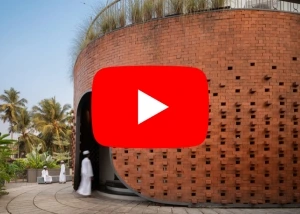Modern mosque design in Kerala with curved brick facade and landscaped entrance at Masjidul Arif