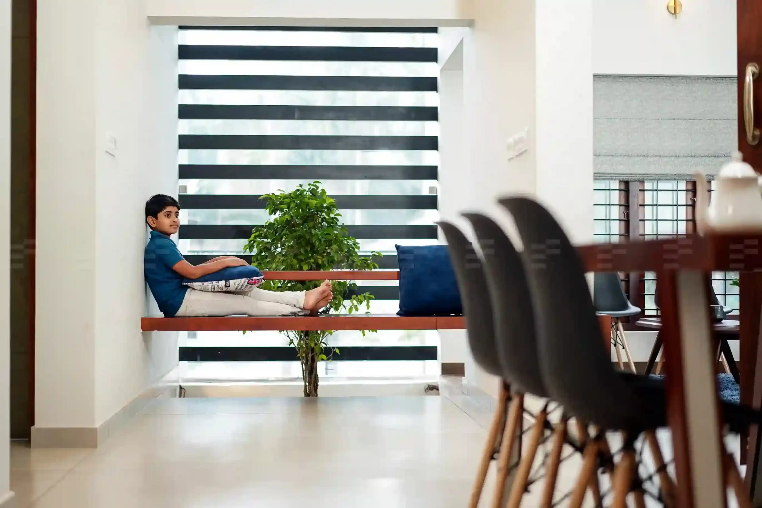 Modern dining setup by top residential architects featuring wooden finishes and greenery views.