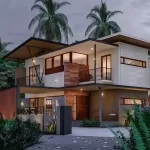 Evening view of a residence, Project by Leading Architects in Calicut, featuring facade lighting and modern material finishes.