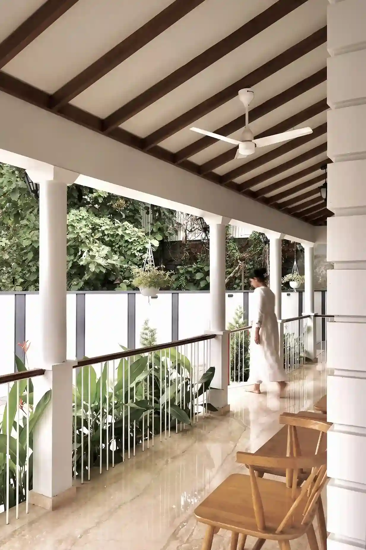 Side view of colonial style sit-out with colonnades, warm lighting, and landscaped plants creating a peaceful outdoor ambiance.